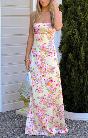 A beautiful pale yellow satin maxi dress adorned with pink and orange floral blooms- designed in a sleek silhouette- perfect for a summer formal or garden party.