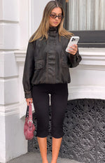 Front view of a brown PU funnel neck jacket with chest flap pockets and an elasticated blouson hem
