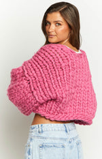 Back view of a cropped blush pink chunky knit cardigan with oversized balloon sleeves