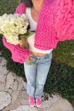 Top-down view of the oversized blossom pink chunky knit cardigan sleeves