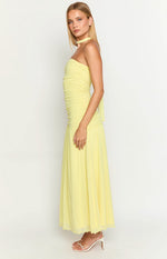 Side view of a yellow strapless ruched maxi dress with a flowy skirt and a choker neck tie