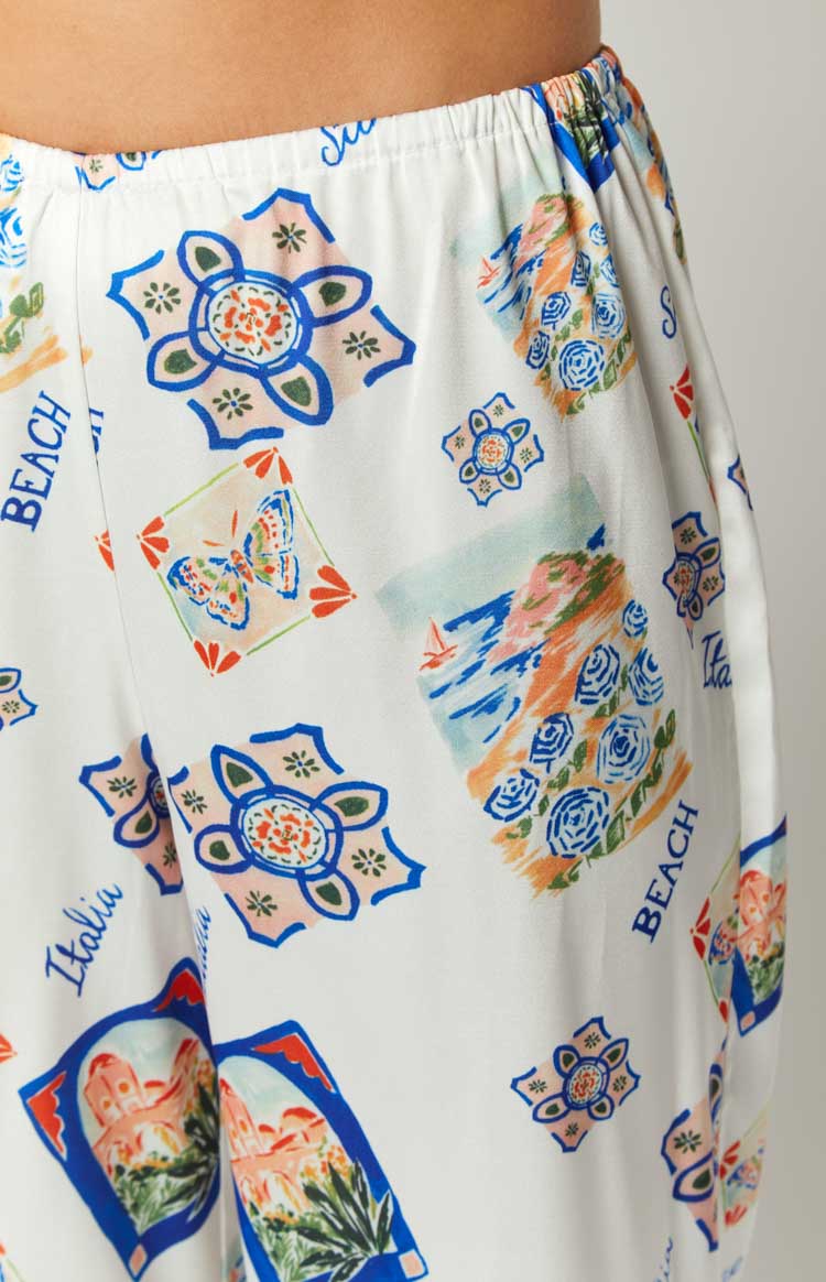 Elasticated waistband detail on white pants with a vibrant Italia print including butterflies and beach scenes