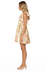 Side view of a yellow floral satin mini dress with tie shoulders and an A-line skirt