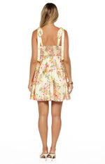 Rear view of a yellow floral mini dress with a smocked back bodice and tie-shoulder straps