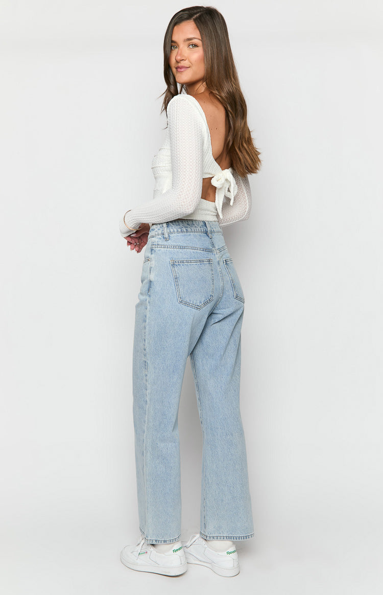 Side view of light wash mid-rise slouchy jeans showing the relaxed fit and wide leg silhouette