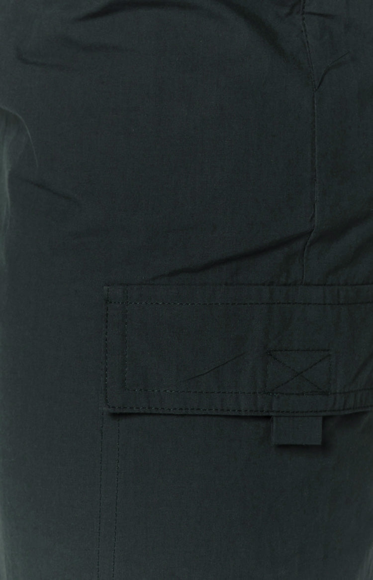 Close-up of the indigo cargo skirt fabric showing a flap pocket with visible stitching