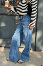 Mid wash blue low rise jeans with a wide leg cut and front button closure