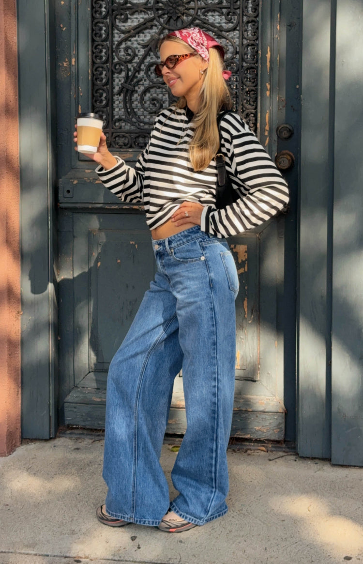 Mid wash blue low rise wide leg jeans with a relaxed fit and full length