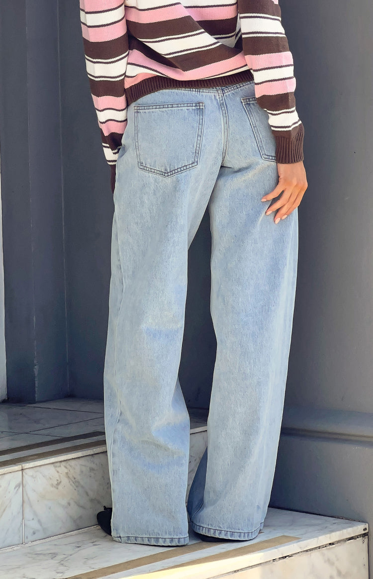 Rear view of light wash low rise jeans with back pockets and a relaxed wide leg fit
