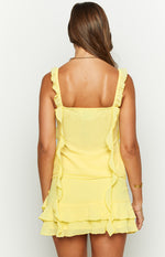 Rear view of a yellow chiffon top featuring a square back neckline, ruffled shoulder straps, and ruffled trim down the back