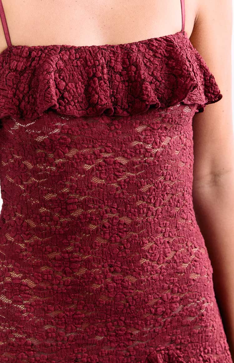 Close-up of the wine lace fabric showing the intricate floral pattern, ruffled off-shoulder detail, and thin spaghetti strap