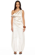 Front view of the cream satin asymmetric top showing the draped bodice and uneven hemline
