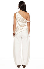 Rear view of the cream satin asymmetric top with one draped off-shoulder sleeve and one thin strap