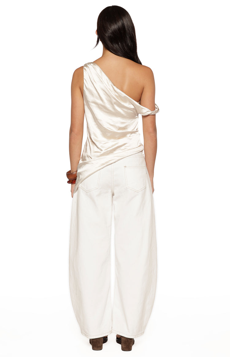 Rear view of the cream satin asymmetric top with one draped off-shoulder sleeve and one thin strap
