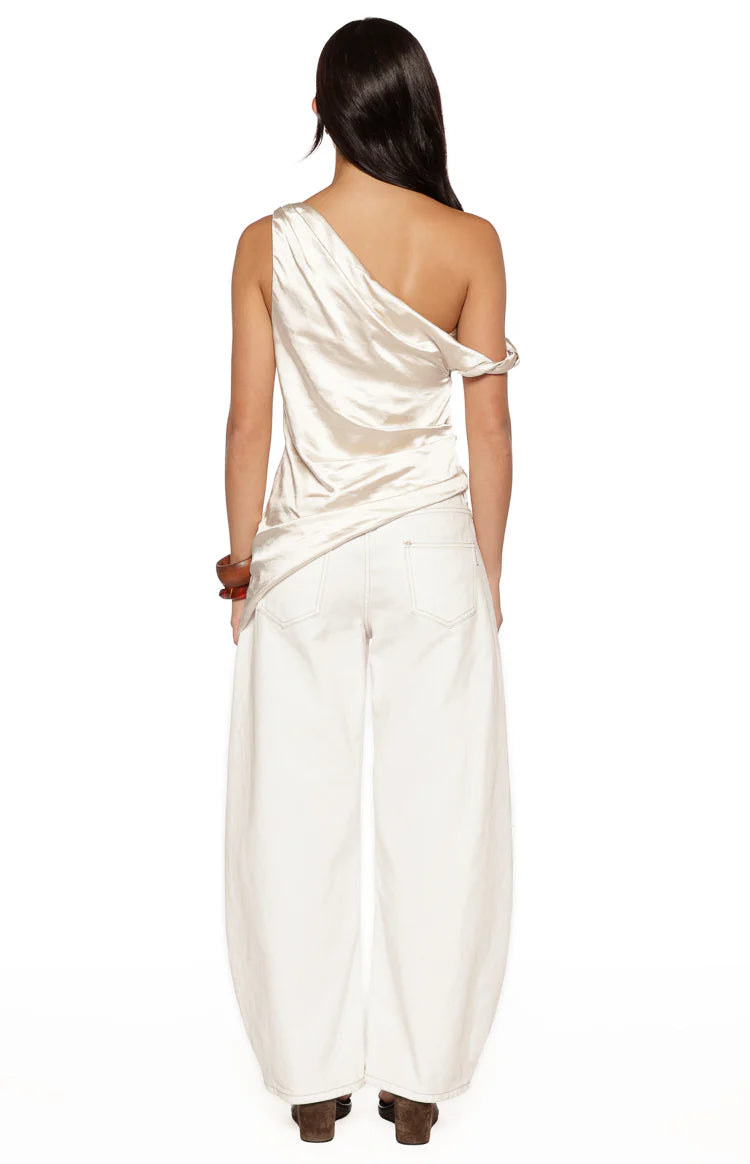 Rear view of the cream satin asymmetric top with one draped off-shoulder sleeve and one thin strap