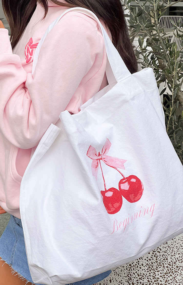 Close-up of the white canvas tote bag's interior showing the magnetic snap closure, internal pocket, and brand label