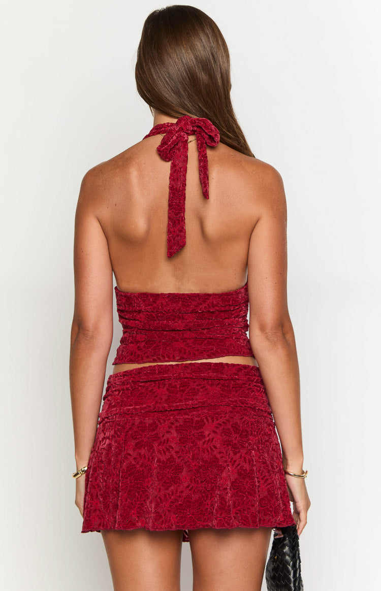 Rear view of a red patterned velvet crop top with a halter neck tie and ruched back detail