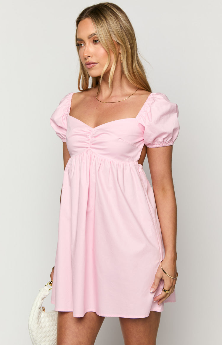 Side view of a light pink mini dress with a sweetheart neckline, ruched bust, puff sleeves, and side cutouts