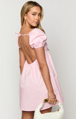 Rear view of a light pink mini dress with an open back, tie detail at the neck, and puffed sleeves