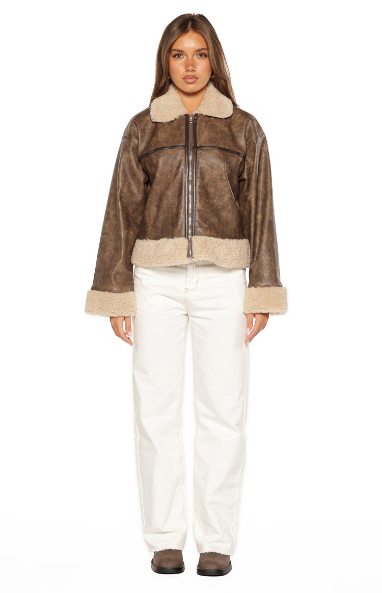 Front view of a cloud brown faux leather aviator jacket with light beige faux shearling collar, cuffs, and hem