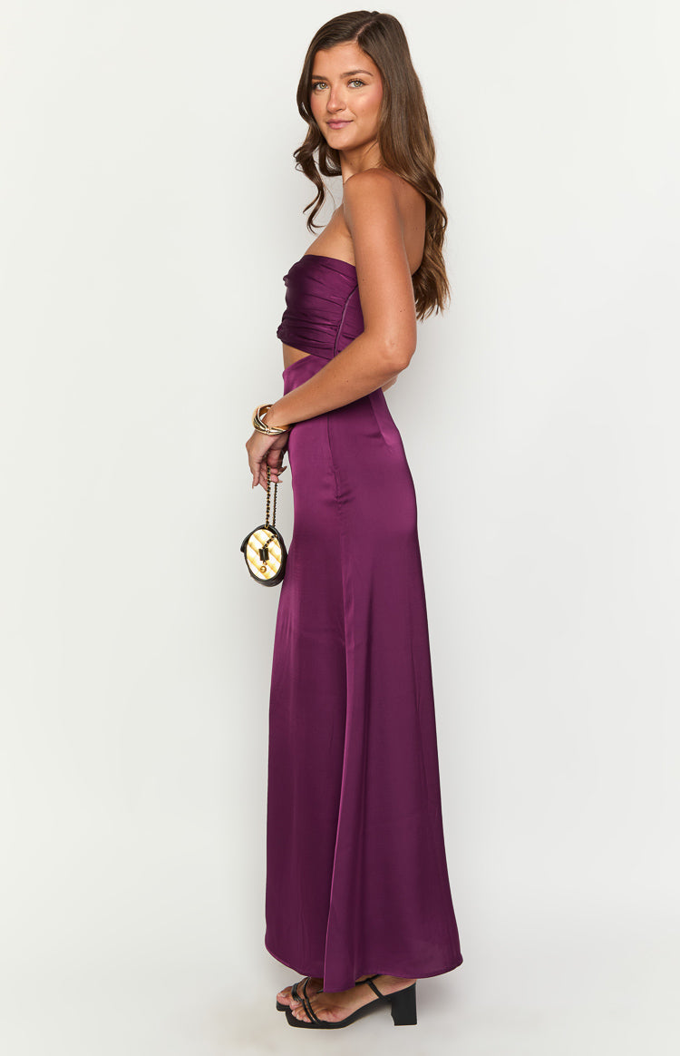 Side view of a purple strapless maxi dress with a ruched bodice, waist cutout, and flowing satin skirt