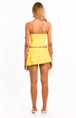 Rear view of a yellow strapless fitted top with a straight back