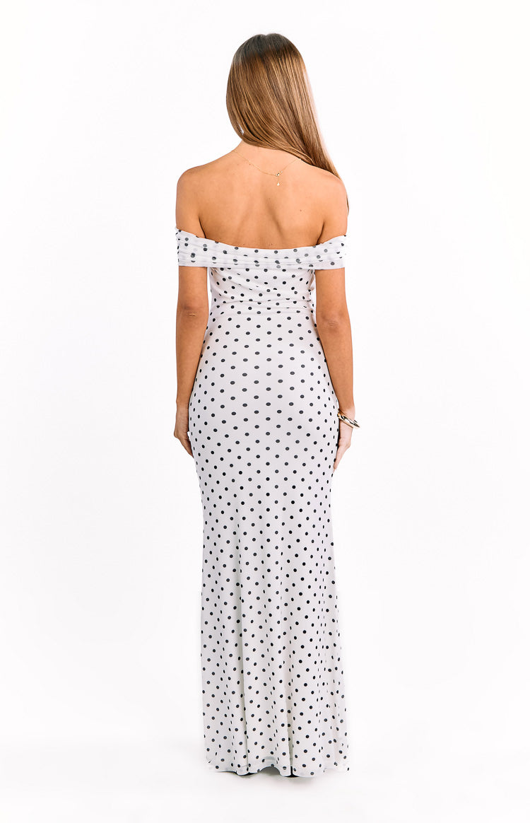 Rear view of a white maxi dress with black polka dots, showing the off-shoulder neckline and fitted silhouette