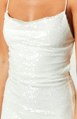 Close-up of the white sequin dress showing the cowl neckline, ruched side detail, and invisible zipper