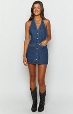 Front view of a blue denim halter neck mini dress with a full button-front closure and two patch pockets