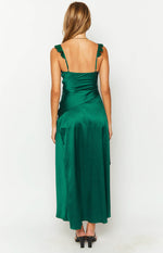 Rear view of a green satin maxi dress with ruffled spaghetti straps and a diagonal seam detail on the flowy skirt