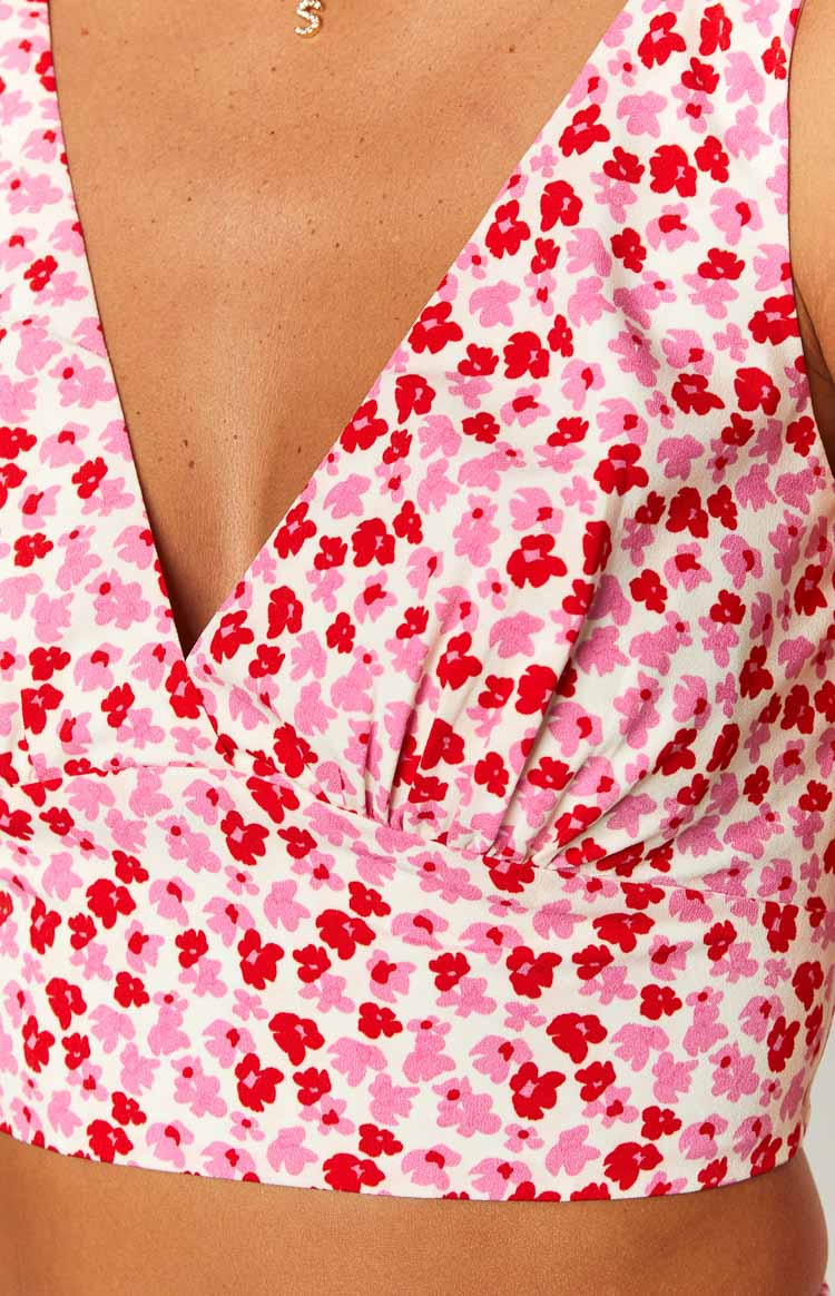 Close-up of the V-neckline and ruched detail on the white crop top with pink and red speckled floral print