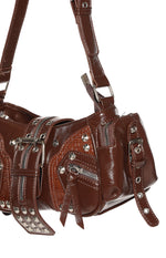 Angled close-up of brown PU shoulder bag with silver hardware, multiple zippers, studs, and crocodile embossed panels