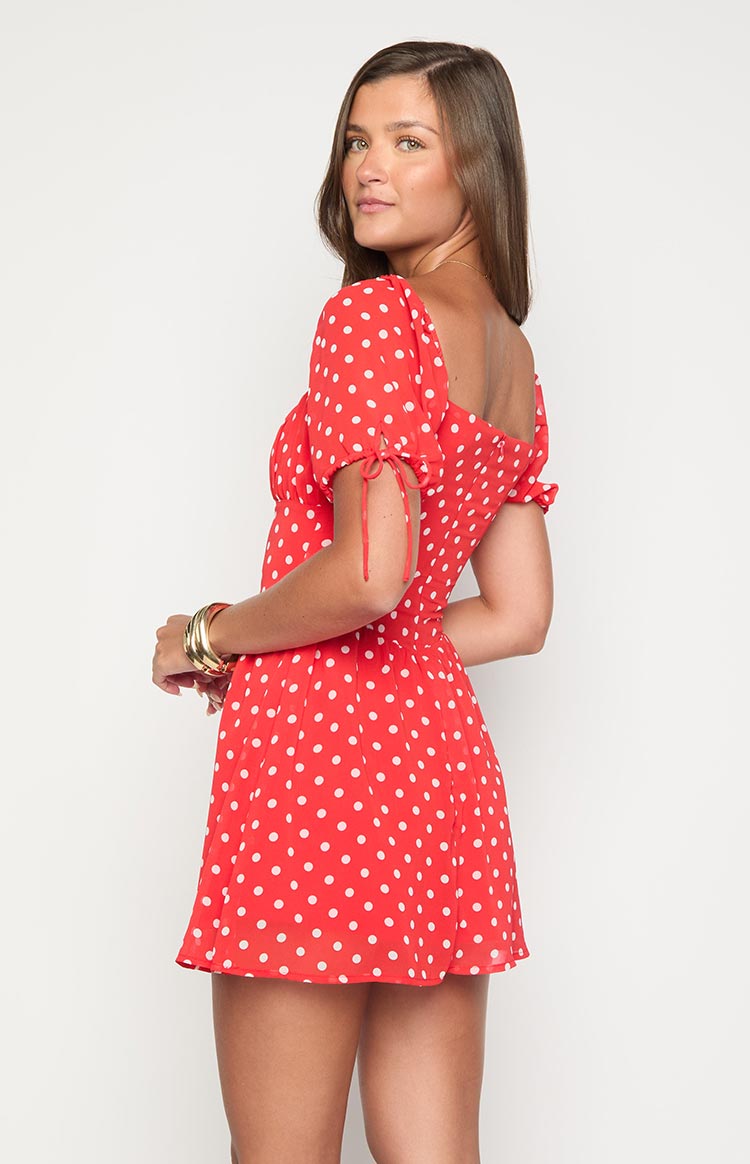 Side view of a red polka dot mini dress showing the puff sleeves with tie details and square neckline