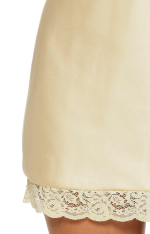 Close-up of the pale yellow satin mini dress hem with delicate floral lace trim
