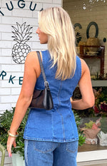 Rear view of the mid-wash denim vest top showing vertical seam detailing and the sleeveless cut