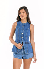 Mid wash denim vest top featuring a button-down front, round neck, sleeveless cut, structured peplum hem, and decorative flap pockets