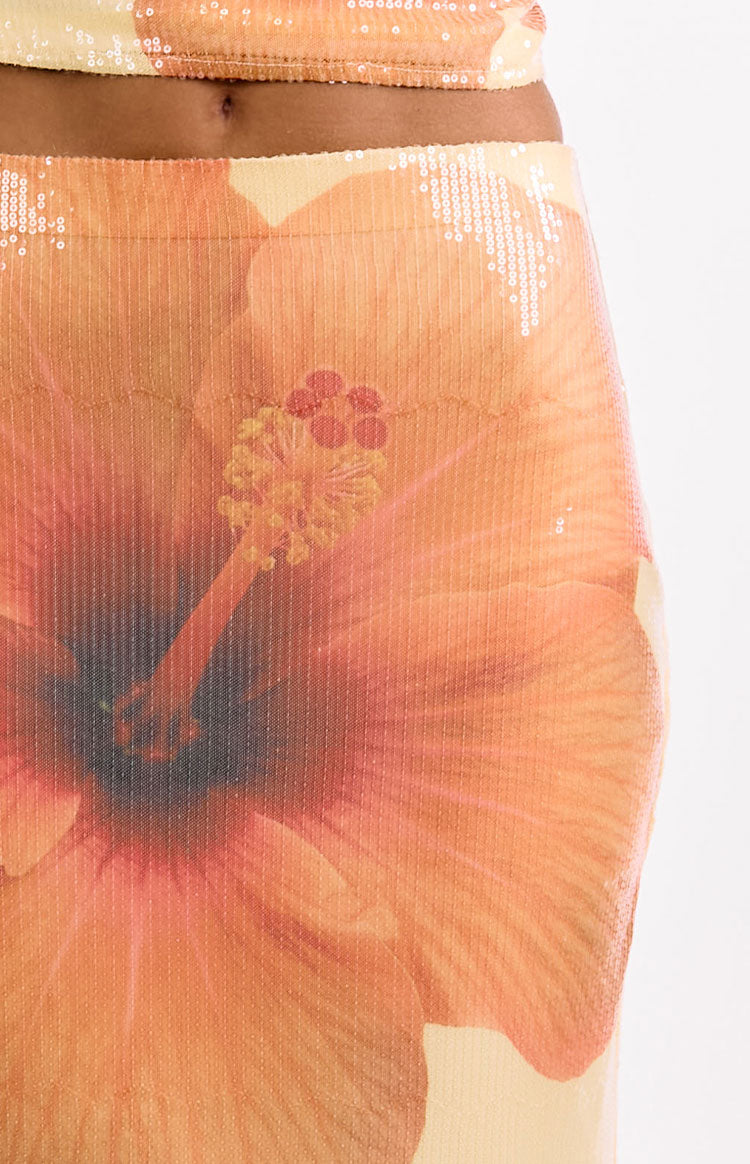 Close-up of the yellow and orange sequin maxi skirt showing the large hibiscus floral print and shimmering sequin texture