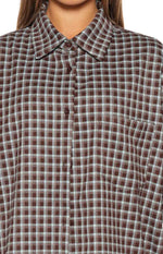 Front close-up of the brown and light blue plaid shirt, highlighting the collar, button placket, and chest pocket
