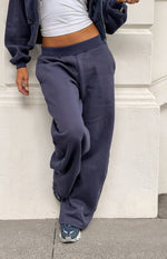 Navy barrel leg track pants with a wide elastic waistband and relaxed, full leg shape