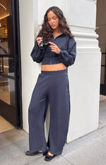 Front view of navy barrel leg track pants with a wide elasticated waistband and relaxed fit