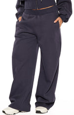 Navy barrel leg track pants with elasticated waistband, side pockets, and curved leg seam detail