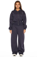 Full length navy barrel leg track pants with a relaxed, voluminous fit