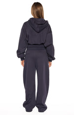 Rear view of navy barrel leg track pants with a wide elasticated waistband and relaxed, slouchy fit