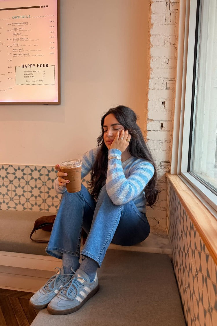 Light blue and white horizontal stripe knit sweater with long sleeves and a relaxed fit