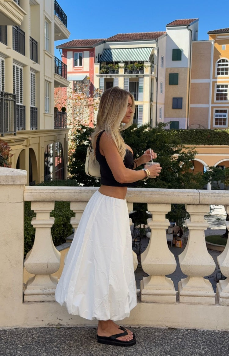 Side view of a white bubble hem skirt with a voluminous, gathered hem and relaxed fit