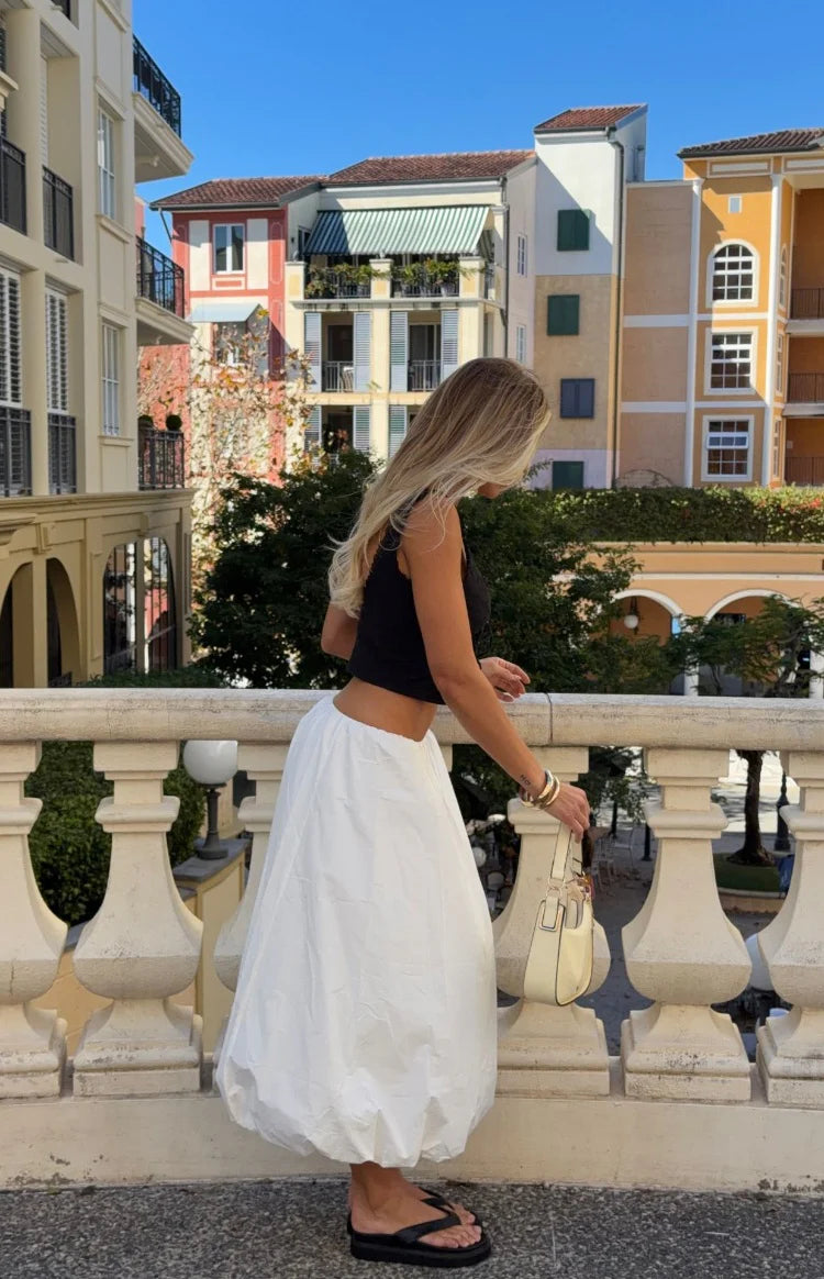 Side view of a white bubble hem skirt with a voluminous, rounded silhouette
