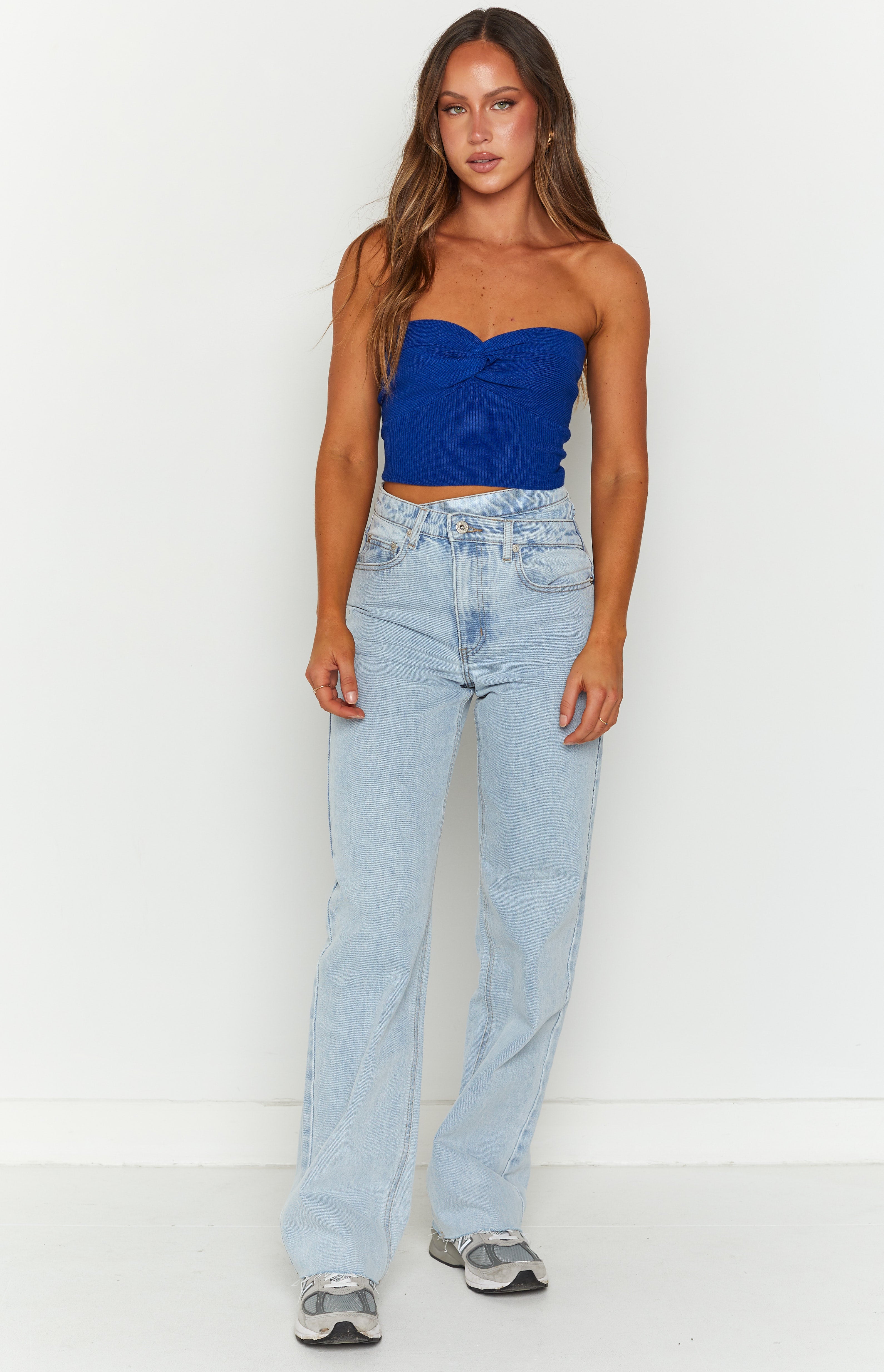 Front view of light blue high-waisted wide-leg jeans with an uneven V-shaped waistband and relaxed fit
