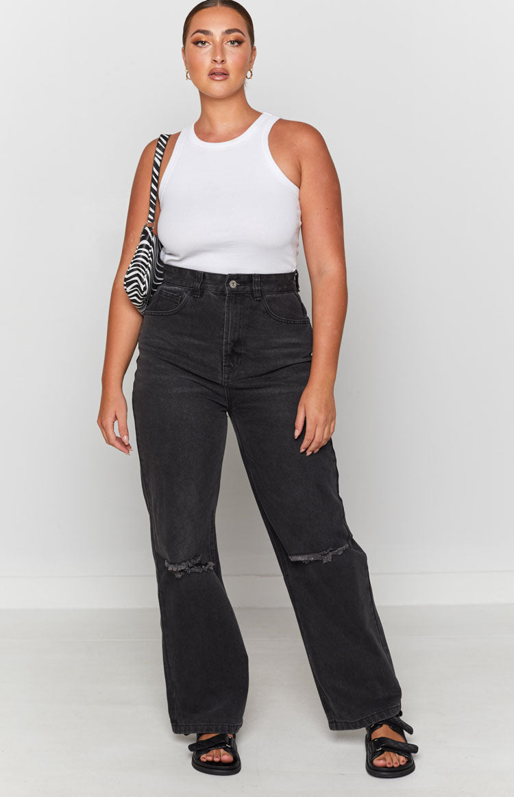 Faded black wide leg jeans featuring distressed knee rips and a raw hem