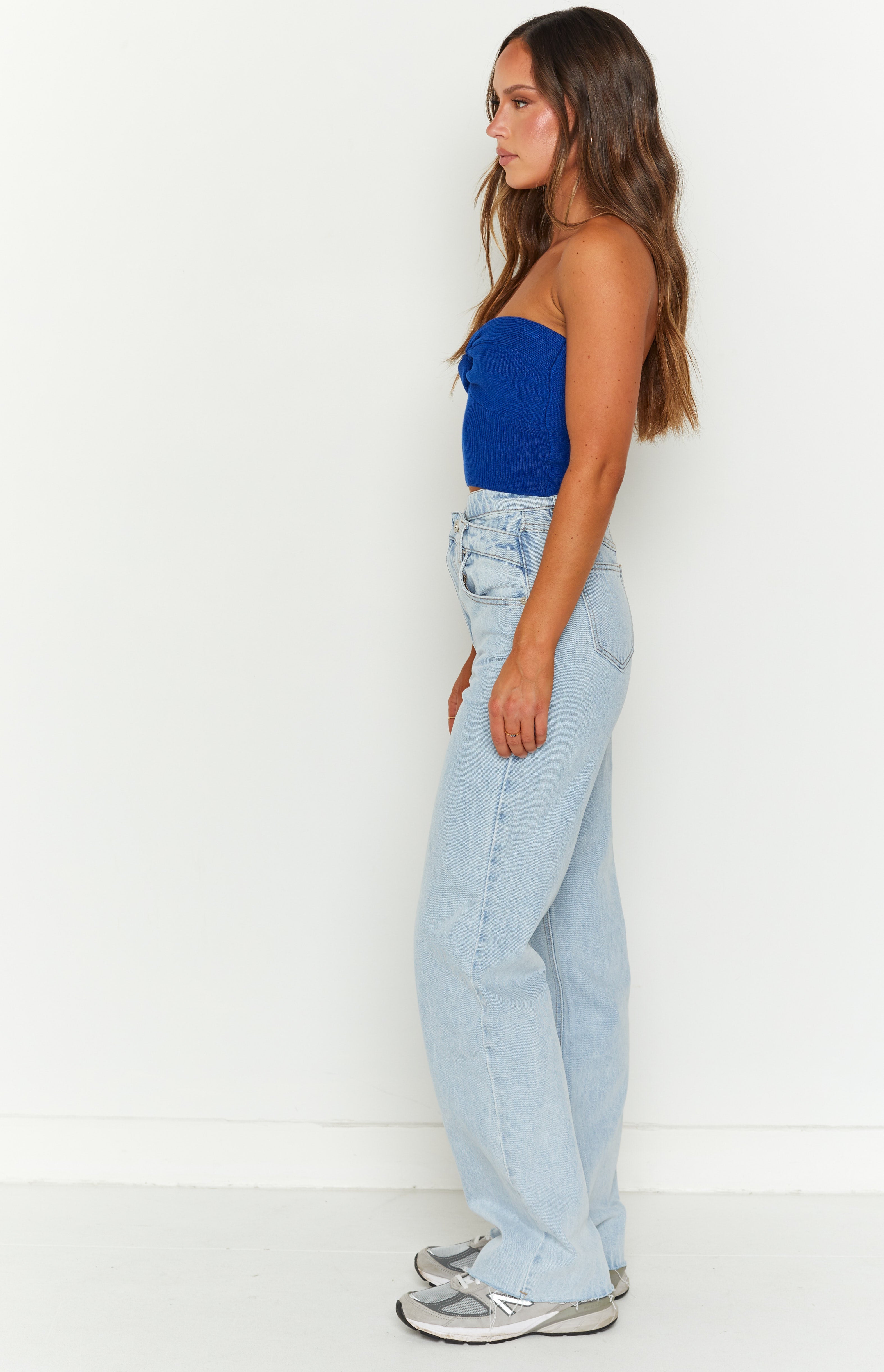Side view of light blue high-waisted relaxed fit jeans with a wide leg