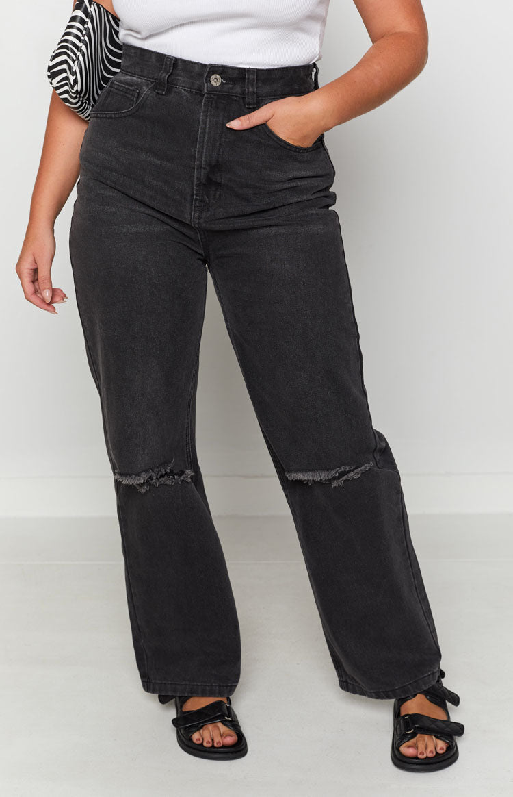 Faded black wide leg jeans with distressed ripped knees and a high-rise waist